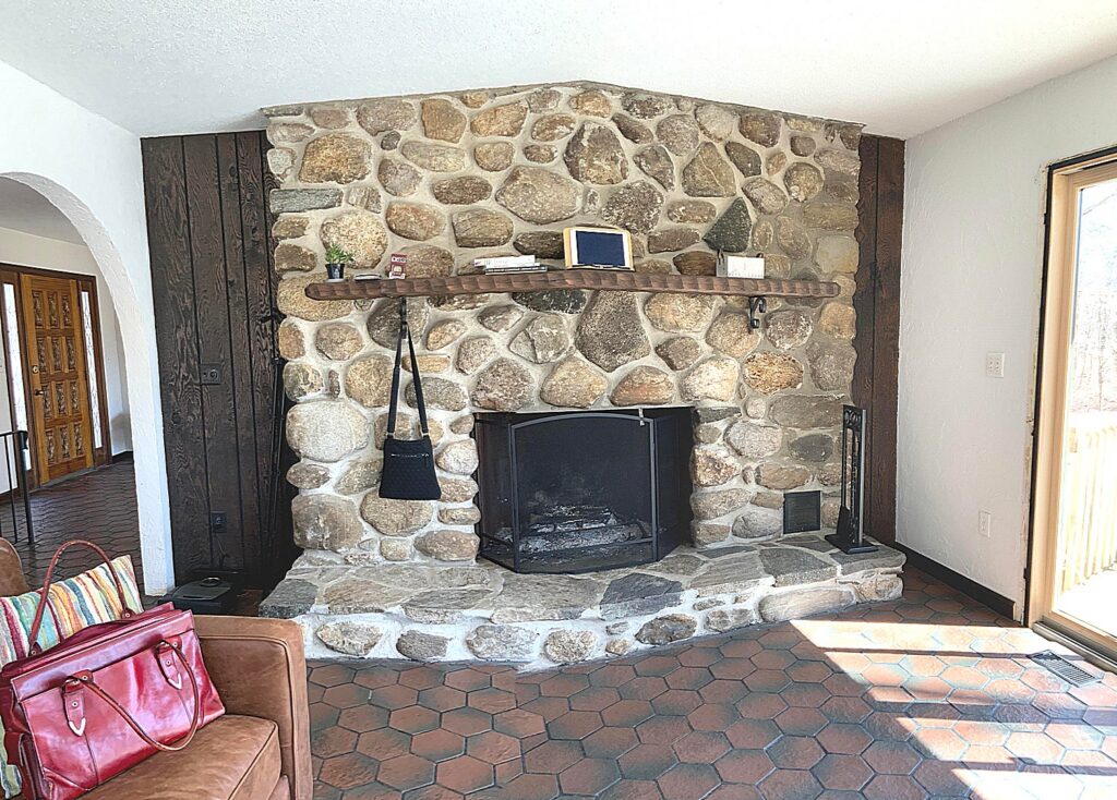 Old southwest style fireplace with over-sized stone over terracotta tile