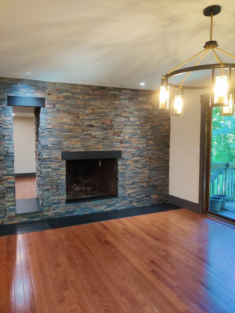 One of two living rooms with fireplace and black granite slab hearth