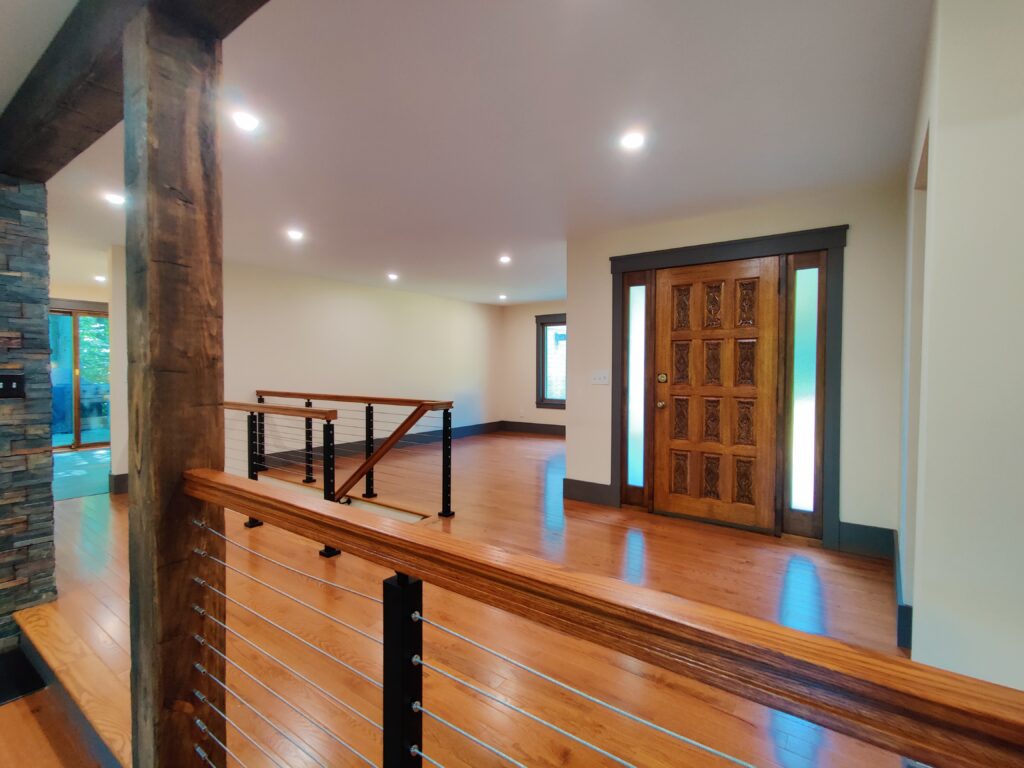 Front entrance with custom oak rails and stainless steel cable railings over solid red oak flooring